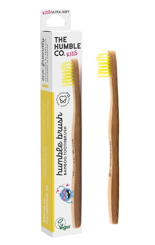 Humble Brush Kinder Zahnbürste mit gelben Borsten, Verpackung im Hintergrund.