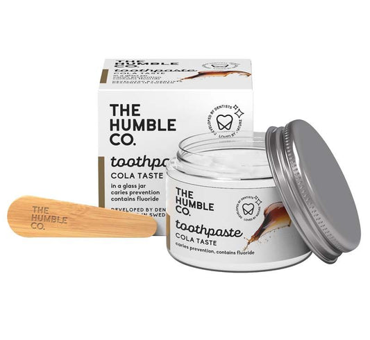 Zahnpasta im Glas mit Cola-Geschmack und Bambuslöffel.