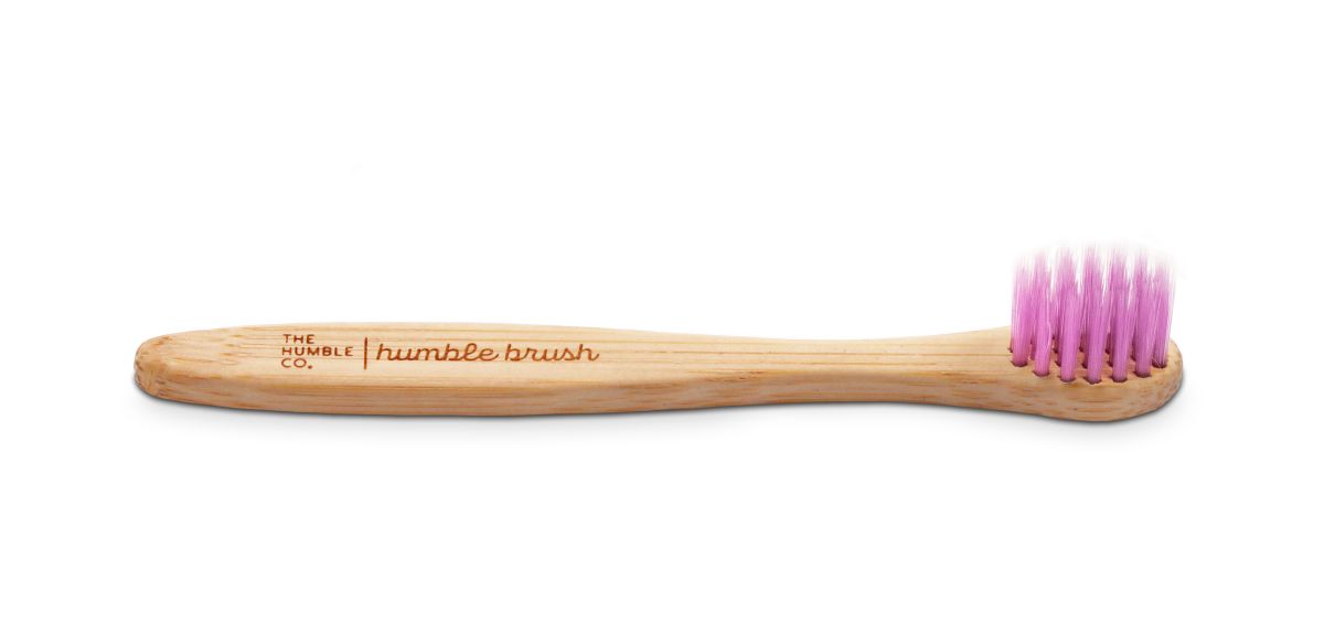 Humble Brush Baby Zahnbürste mit lila Borsten und Holzgriff in Nahaufnahme.