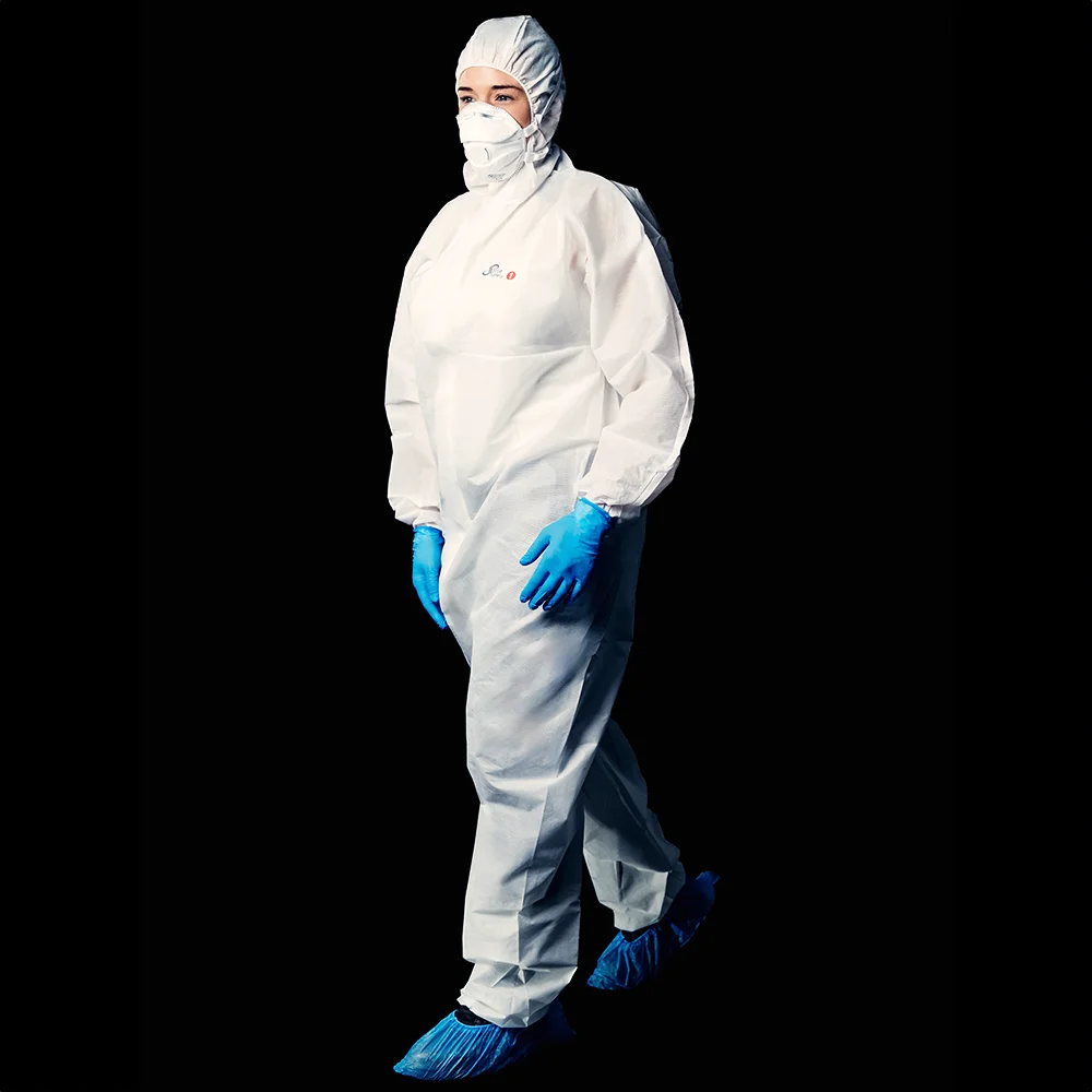 Schutzanzug mit blauen Nitrilhandschuhen und Überziehschuhen in Laborumgebung.