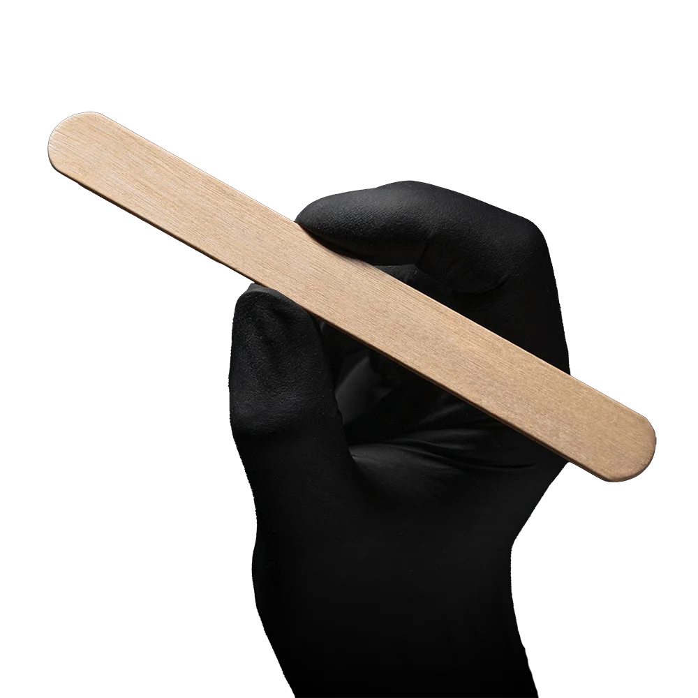 Schwarzer Handschuh hält einen splitterfreien Holzmundspatel mit abgerundeten Kanten.