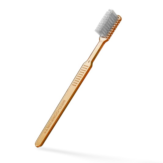 Einwegzahnbürste mit Zahnpasta, orange, aus Polystyrol.