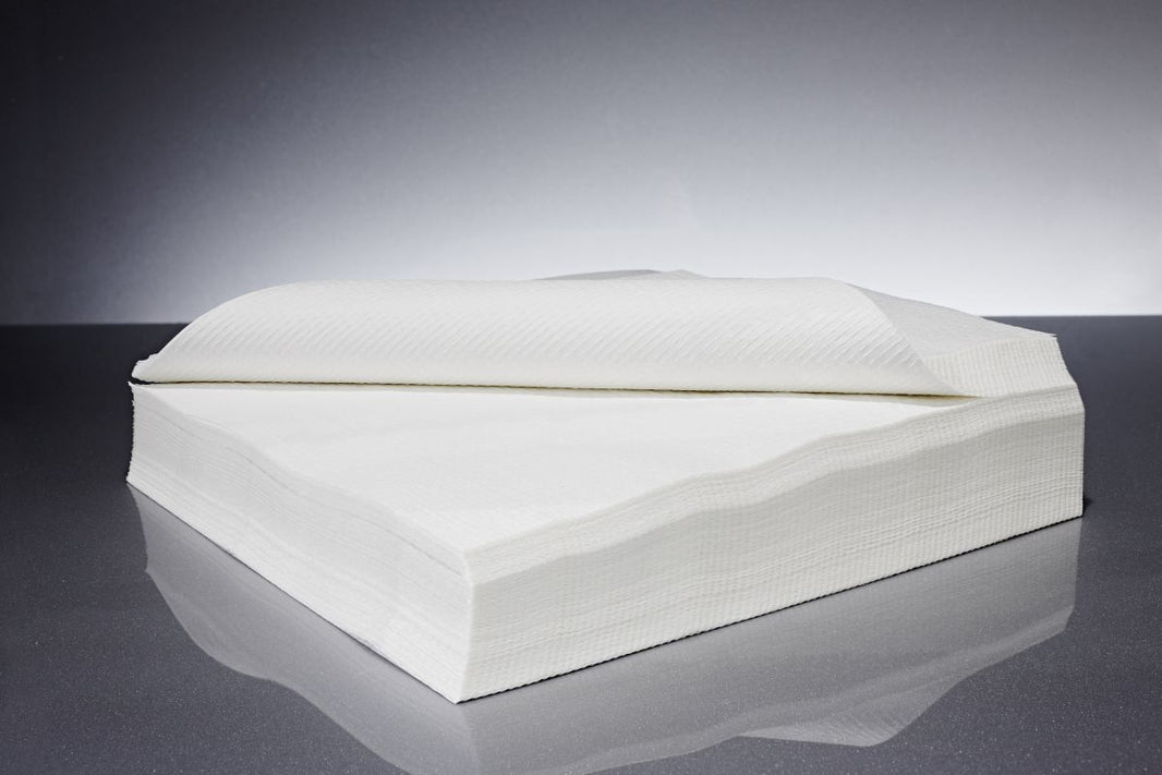 Hochwertige weiße Kreppservietten für den medizinischen Gebrauch auf grauem Hintergrund.