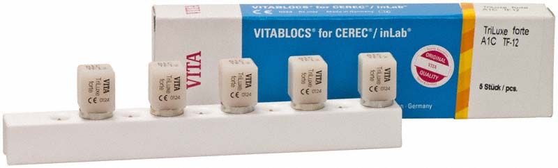 VITABLOCS® TriLuxe forte Zähne in Halterung mit Verpackung im Hintergrund.