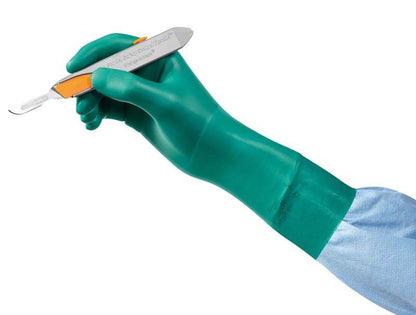 Grüner, puderfreier OP-Handschuh aus Latexersatzmaterial beim Halten eines Skalpells.