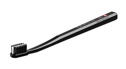 Schwarze CURAPROX Zahnbürste mit weißen Borsten und Schweizer Flagge auf dem Griff.