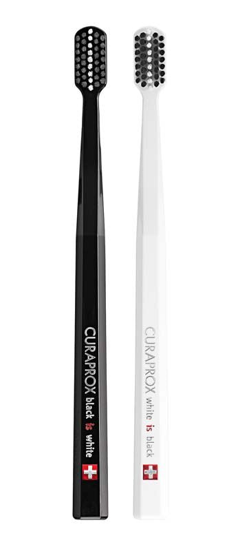 Zwei CURAPROX Black is White Zahnbürsten in Schwarz und Weiß.