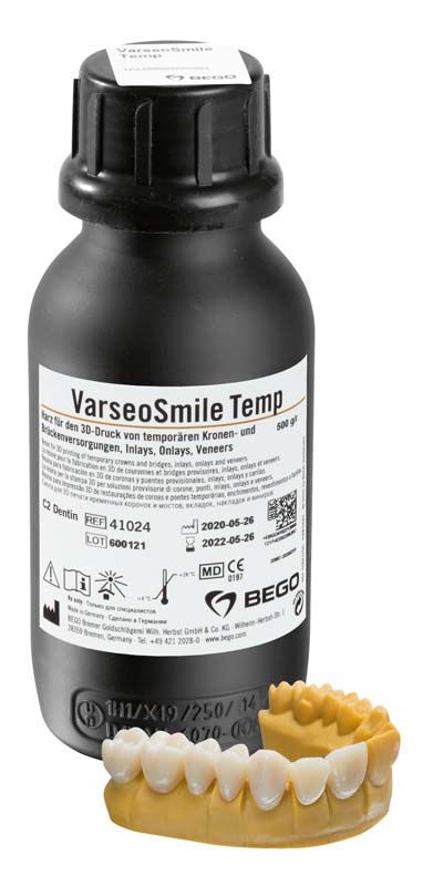 Schwarze Flasche VarseoSmile Temp C2 mit Zahnprothese auf weißem Hintergrund.