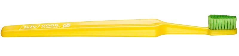 Gelbe TePe GOOD™ Zahnbürste Compact Soft mit grünem Bürstenkopf.