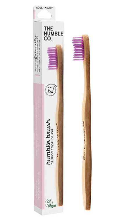 Humble Brush Zahnbürste mit lila Borsten und Verpackung in Nahaufnahme.