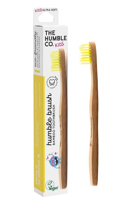 Humble Brush Kinder Zahnbürste mit gelben Borsten, Verpackung im Hintergrund.