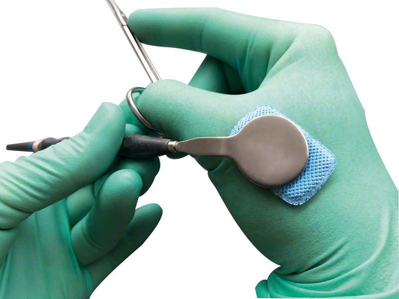 Hochabsorbierendes Fit-N-Swipe Trocknungspad in Gebrauch an dentalem Instrument.