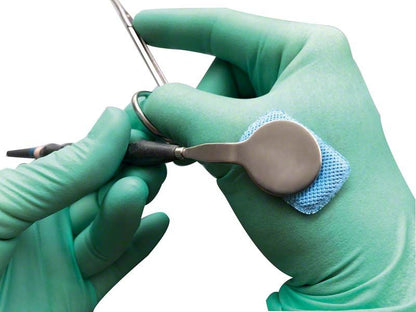 Hochabsorbierendes Fit-N-Swipe Trocknungspad in Gebrauch an dentalem Instrument.