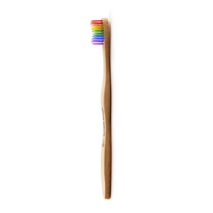 Zahnbürste mit Bambusgriff und regenbogenfarbenen Borsten, seitlich abgebildet.