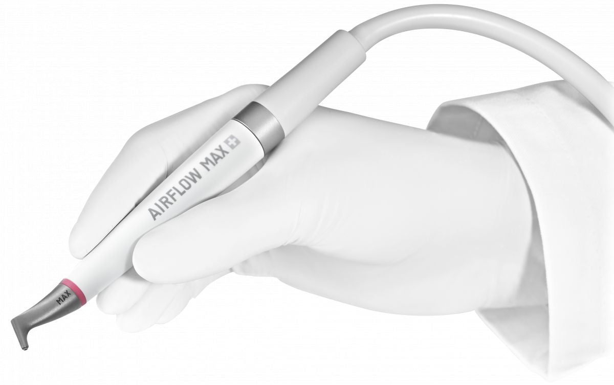 AIRFLOW® MAX SMART Handstück in einer behandschuhten Hand gehalten.