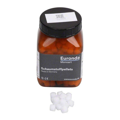 Braune Kunststoffdose mit Monoart Schaumstoffpellets, 8mm, und lose Pellets davor.