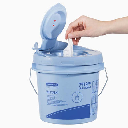 Hand zieht WypAll® Wettask™ Wischtuch aus blauer Spenderbox.
