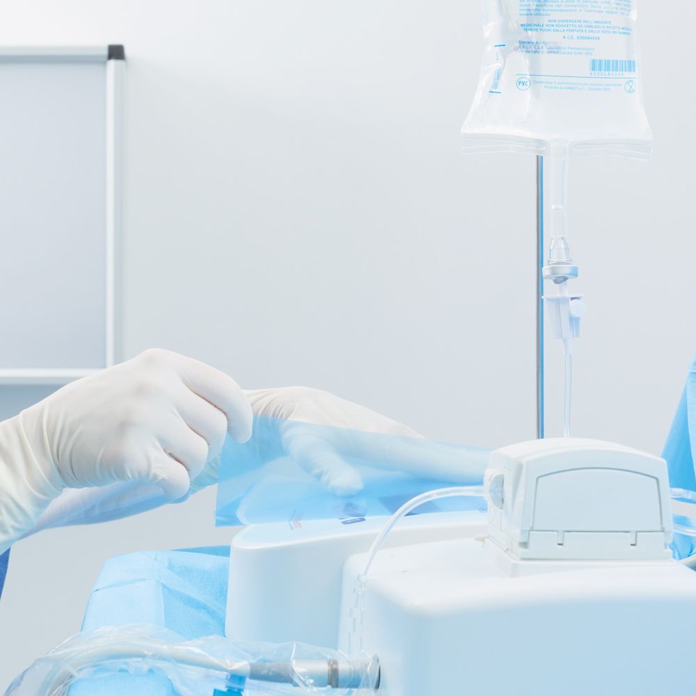 Selbstklebende Schutzfolie wird auf medizinisches Gerät im Dentalbereich aufgebracht.