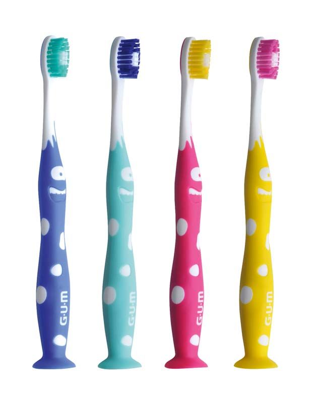 Vier bunte GUM® JUNIOR Zahnbürsten mit Punkten und lustigem Gesichtsmuster.