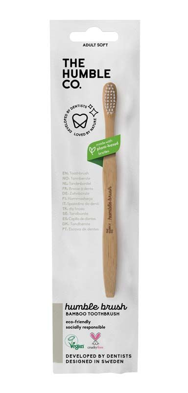 Humble Brush Zahnbürste mit Bambusgriff und weichem weißen Borstenkopf in Verpackung.
