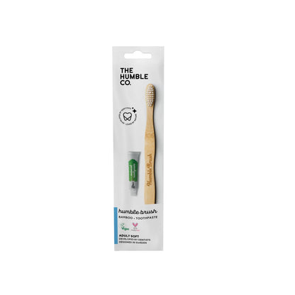 Bambuszahnbürste und Zahnpastatube von Humble Brush in weißer Verpackung.