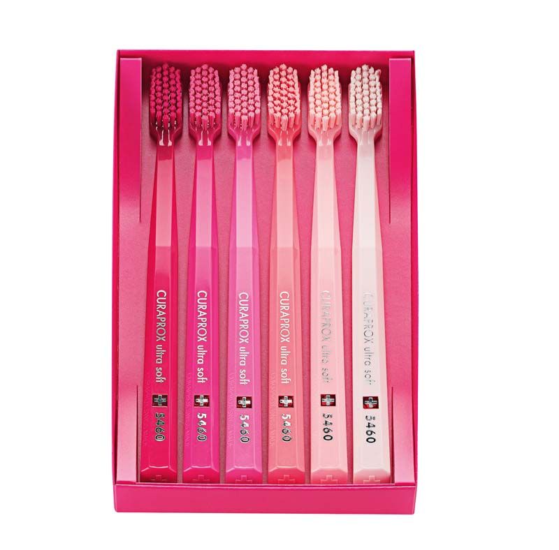 Sechs CURAPROX Zahnbürsten CS 5460 im rosafarbenen Geschenkkarton.