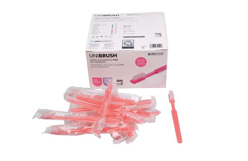 Einmalzahnbürsten pink, einzeln verpackt, vor einer Verpackungseinheit mit 100 Stück.