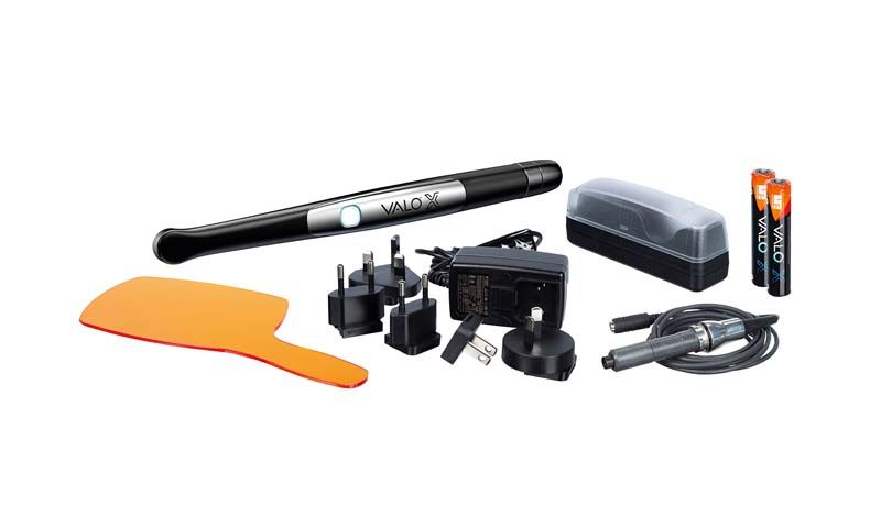 VALO™ X Kit mit Handstück, Ladegerät, Schutzschild und Zubehör auf weißem Hintergrund