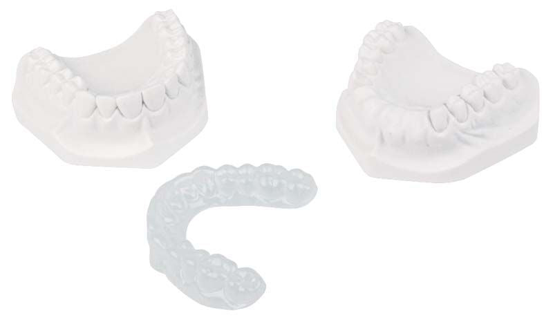 Drei dentalmedizinische Tiefziehfolienformen auf weißem Hintergrund.