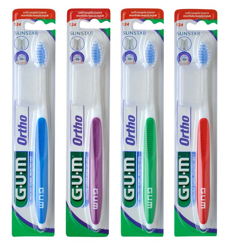 Vier GUM® KFO-Zahnbürsten in verschiedenen Farben in Originalverpackung.