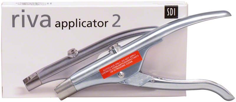Riva Applikator aus Metall mit Produktverpackung im Hintergrund.