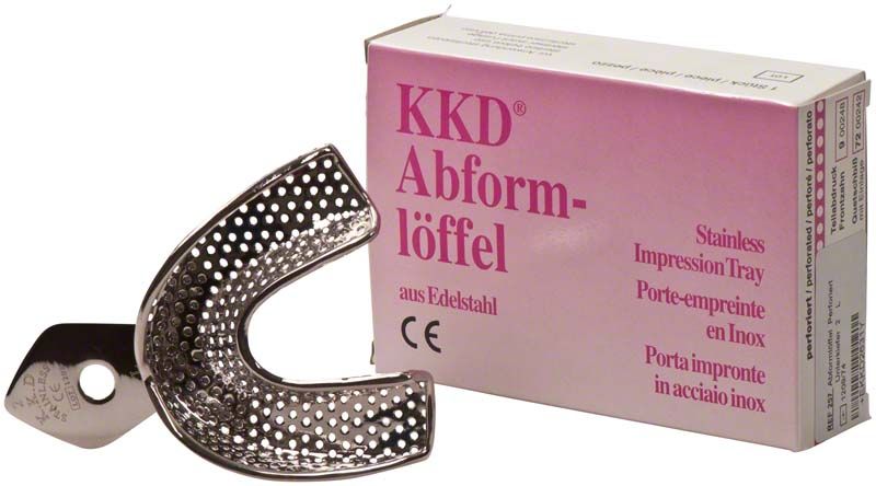 Abformlöffel perforiert aus Edelstahl mit Verpackung im Hintergrund.