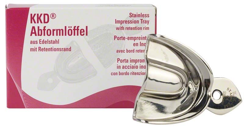 Abformlöffel aus Edelstahl mit Retentionsrand neben Verpackung.