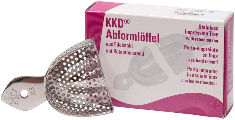 Abformlöffel aus Edelstahl mit Perforationen und Produktverpackung im Hintergrund.