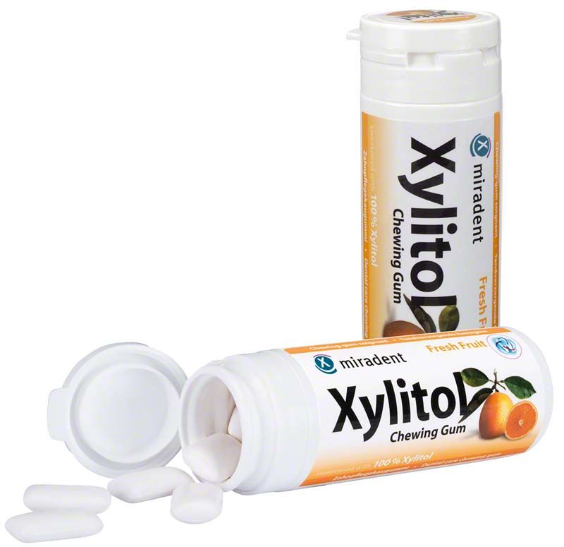 Dose mit miradent Xylitol Chewing Gum Fruchtgeschmack, geöffnet mit sichtbaren Kaugummis.