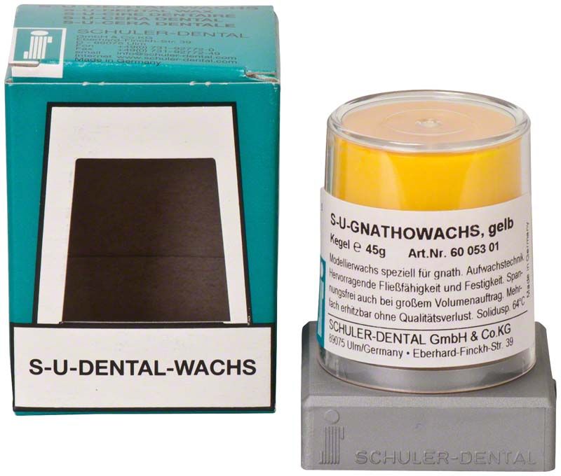 S-U-Gnathowachs gelb in transparentem Behälter neben Verpackung.