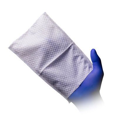 Feuchter Einweg-Waschhandschuh in genoppter Struktur auf blauer behandschuhter Hand.
