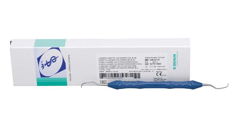 Universalkürette mit blauem Griff und Verpackung im Hintergrund.