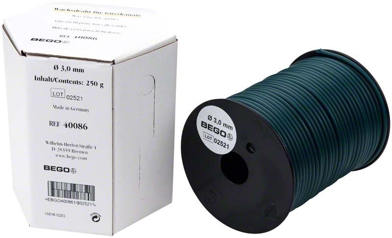 Grüner Wachsdraht für Gusskanäle auf Spule neben Verpackung.