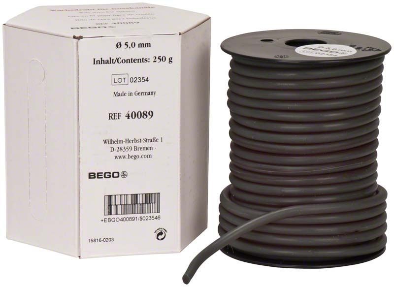 Wachsdrahtrolle für Gusskanäle, grün, mittelhart, 5,0 mm, neben Verpackung.