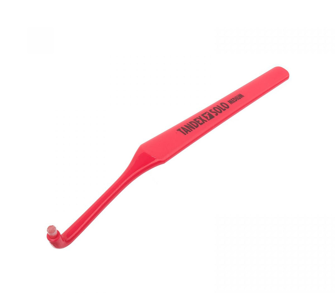 Tandex Einbüschelbürste 1 Solo in roter Farbe mit abgewinkeltem Griff.