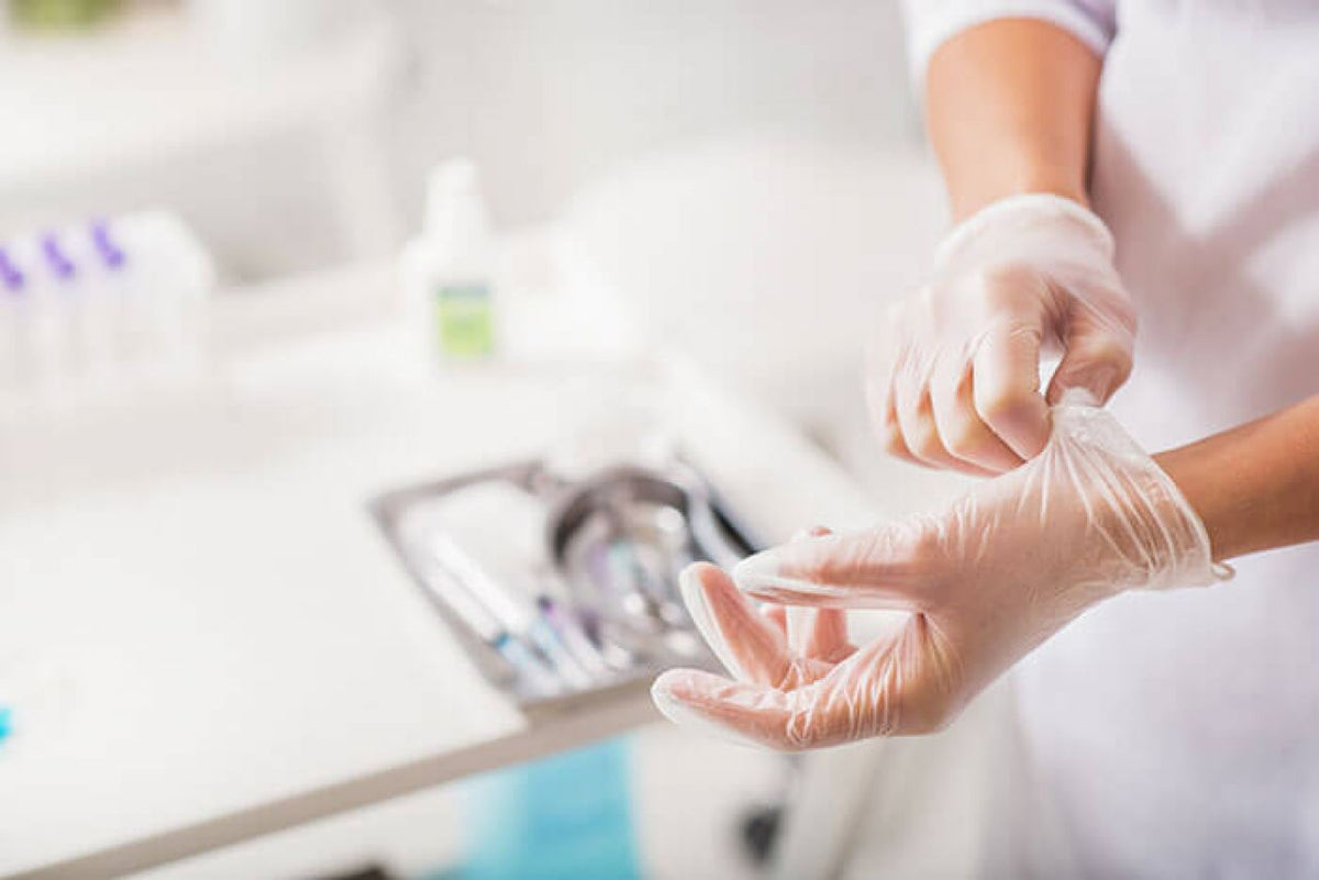 Vinylhandschuhe Größe L, angezogen von Hand in medizinischer Umgebung.