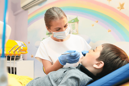 Zahnärztin mit Viawant Yellow Star Nitrilhandschuhen behandelt Kind unter Regenbogenmotiv.
