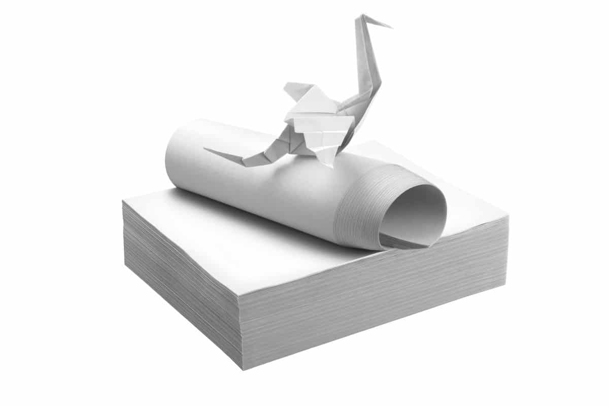 Nasskreppservietten in weiß mit Origami-Kranich darauf.