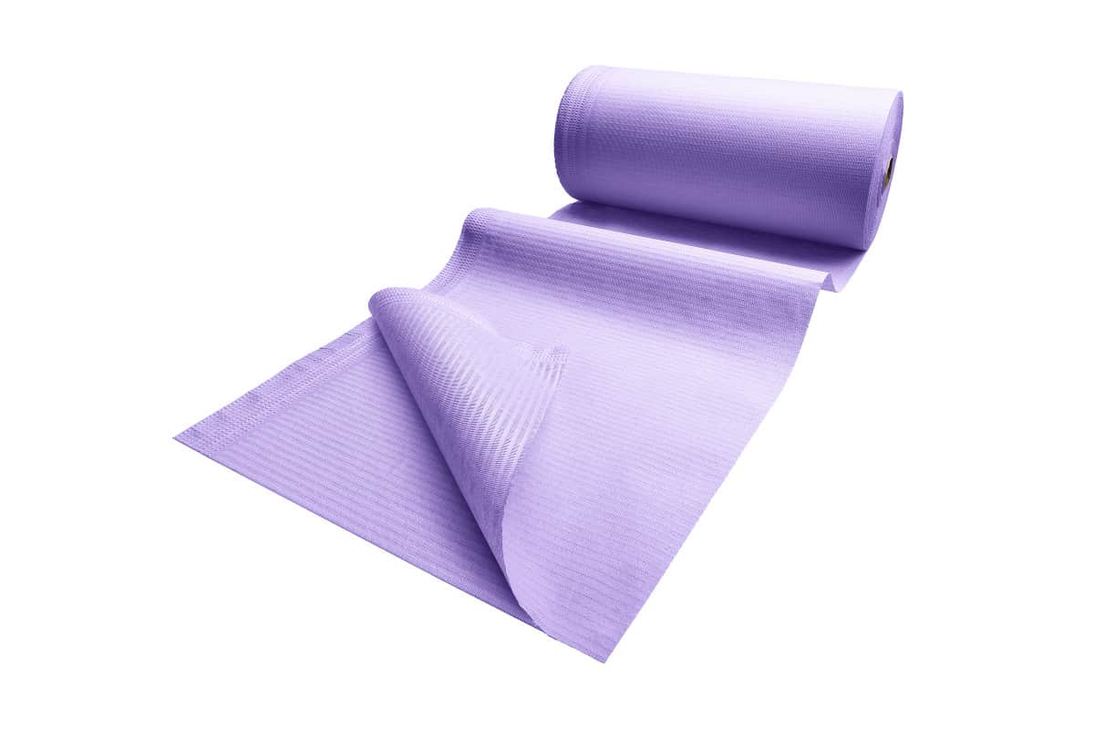 Patientenumhang aus Polyethylen in lila, teilweise abgerollt, auf weißem Hintergrund.