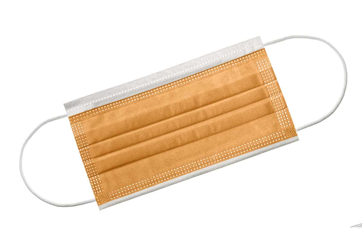 Orangefarbener 3-lagiger Mundschutz mit elastischen Gummibändern und Nasenbügel.