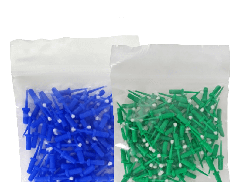 Blaue und grüne beflockte Einmal-Miniatur Applikatoren in Plastikverpackungen.