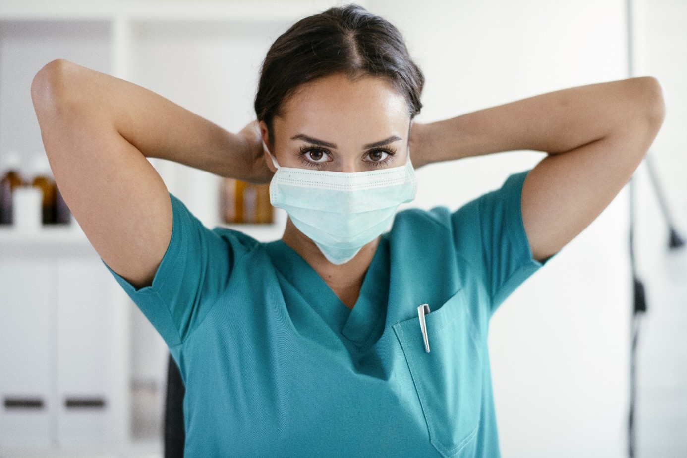 medizinische Angestellte setzt OP-Maske auf